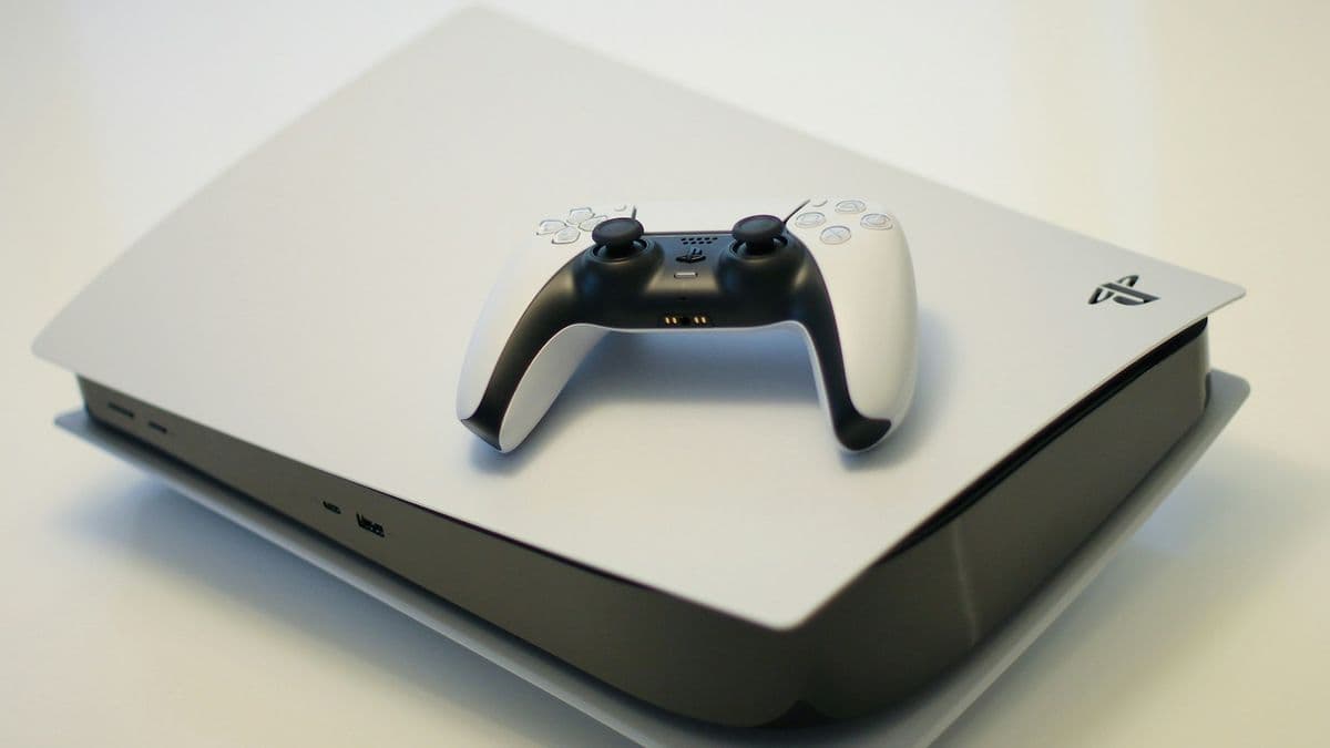 A PlayStation 5 lying flat with a DualSense controller on top